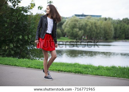 Teens fashion. Portrait of a young brunette girl in the background of a summer park