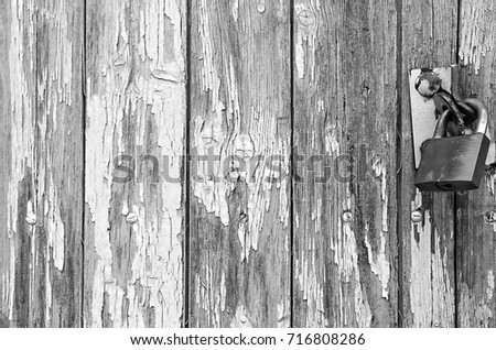 Aged worn cracked and painted blue vertical wooden board planks with padlock. Monochrome backgroundtexture. Close up. Sadness concept. Copy space