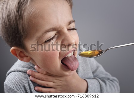 Sick boy unhappy about taking medicine on a spoon