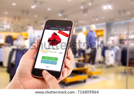 online shopping concept.close-up of hands using touch screen smartphone in department store as background