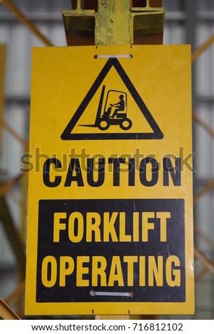 Warning sign in an industrial environment, forklift in operation.