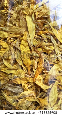 Helianthus or sunflower petals in a glass bottle. Dried sunflowers as background picture. Dry sunflower for perfume, cosmetic, alternative medicine, herbal tea and bath. Yellow organic herb. 