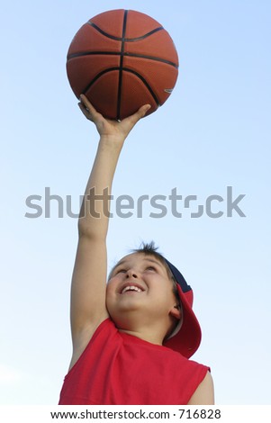 Boy in red shirt with a basketball against the sky 200 iso
