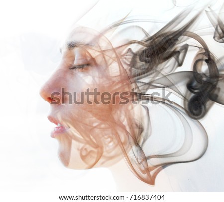 Double exposure portrait of a young fair-skinned woman and a smoky texture dissolving into her facial features