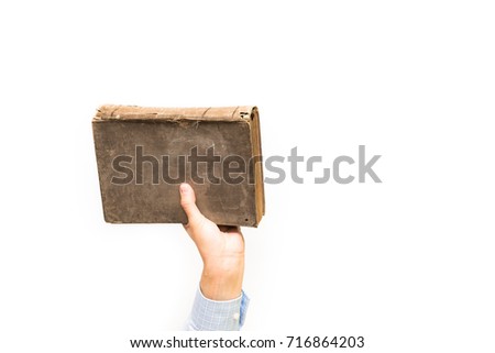 Hand holding book. Male hand holding rusty, old book in the air. Isolated on white background.