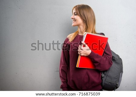Student woman looking lateral on grey background