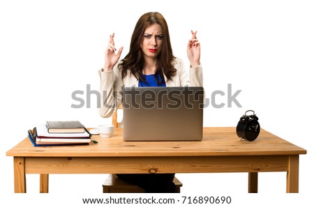 Business woman working with her laptop and with her fingers crossing