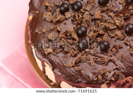 Close-up of homemade chocolate cake on pink background.
