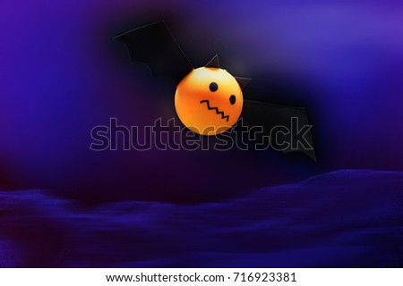Bat cartoon made from a orange round ball fly on deep blue scene. Cute cartoon in Halloween.