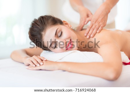 Massage Luxury Lady Relax Body Spa Therapy - Woman Lying closed eyes having a wellness back massage spa treatment feeling visibly good - Healthy Lifestyle and Massage Relaxation Concept Royalty-Free Stock Photo #716924068