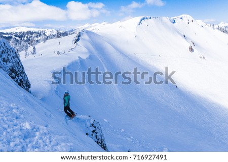 Mixed race woman on snowboard balances on a cliff and smiles