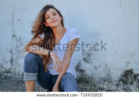Beautiful fashion girl model, wearing basic casual look, sit on ground