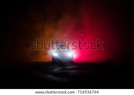 Police car chasing a car at night with fog background. 911 Emergency response police car speeding to scene of crime. Selective focus