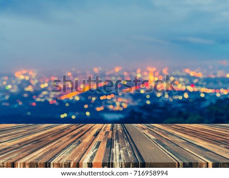 vintage tone image of wood table and blurred city bokeh background with colorful lights .