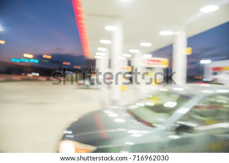 Blurred image of gas station in Houston, Texas, US at twilight. Defocused, out of focus gas station and convenience store at night. Abstract blur petrol station, industrial background with copy space