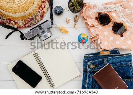 Clothing traveler's Passport, wallet, glasses, smart phone,notebook on a wooden floor in the luggage ready to travel.Travel concept