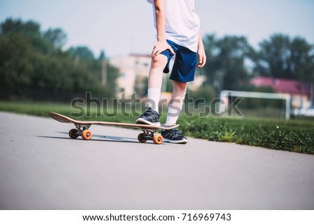 Skateboarder legs. Boy riding skateboard outdoor. Child practicing outside.