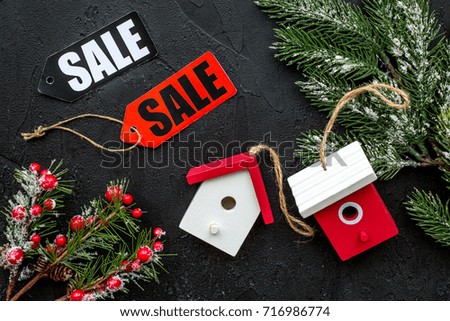 Christmas sale. Sale labels near spruce branch and xmas toys on black background top view