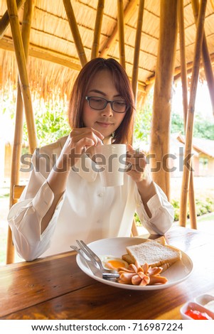 Asian woman drink coffee in morning. live in resort and eatting breakfast.