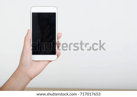 Woman hand holding smartphone with blank screen isolated on white background.