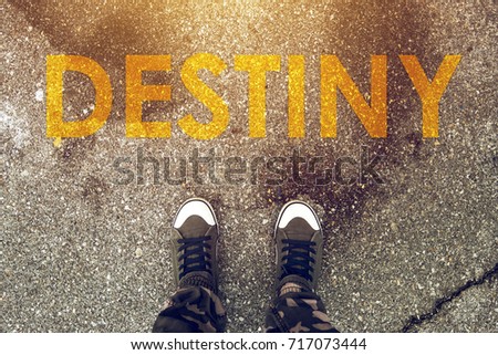 Young person standing on the road with Destiny imprint on pedestrian walkway. Making right choices and deciding about future steps determines your fate. Royalty-Free Stock Photo #717073444