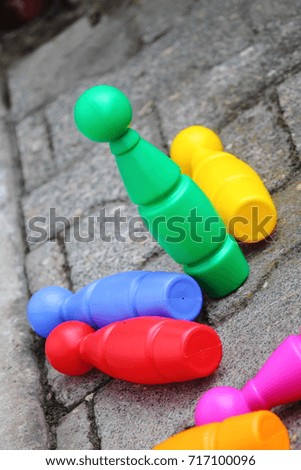 Bright colored children plastic bowling game. Green pin standing.