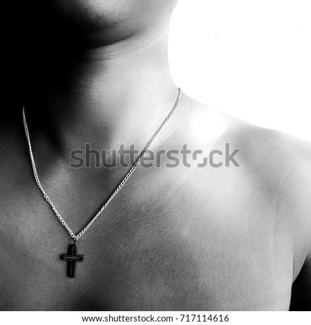 Man chest with strength Christ cross necklace, monochrome art process with selective focus