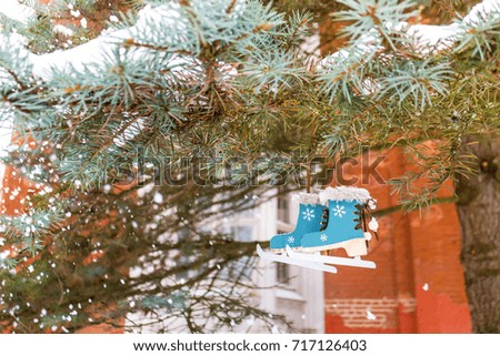 Christmas decor tree skates on the green fir branch in snowflakes