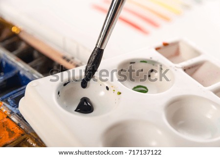 Close up of artist using palette and brush for painting at workplace