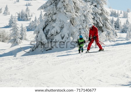 Ski instructor and little boy on mountain
