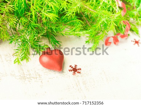 Christmas or New Year background: fir tree branches, red glass balls and toy, decoration and cones on a white wooden background