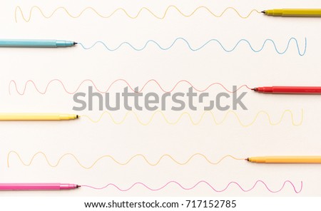 Different wavy lines painted with colorful markers on white paper