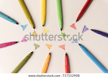 Wi-fi lines drawn with different colorful markers on white paper. Markers lying in group