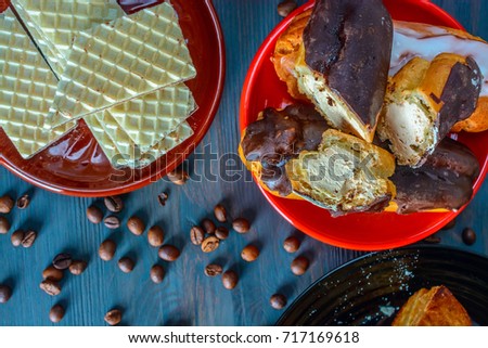 eclairs on a red plate on a wooden background