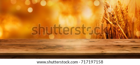 Golden bokeh autumn background with empty wooden table for a thanksgiving decoration