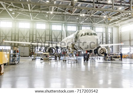 Passenger aircraft on maintenance of engine and fuselage repair in airport hangar Royalty-Free Stock Photo #717203542