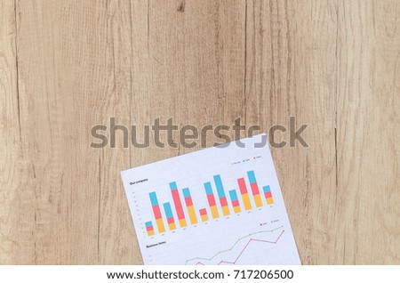 Workplace on wooden table with graph papers