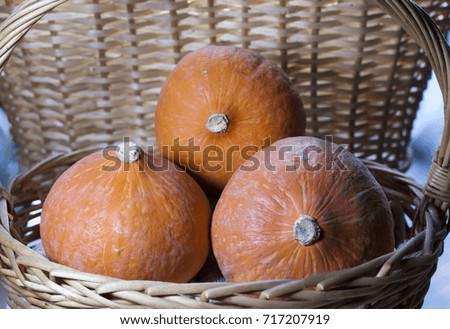 three pumpkins in a wicker basket

