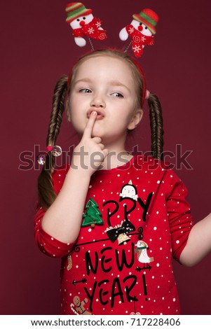 Funny little girl in the New Year's image, showing different emotions. Photo taken in studio