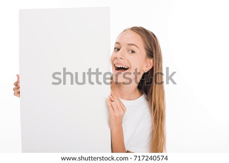 excited adorable female child holding empty board, isolated on white