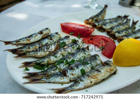 Barbecued Sardines on white plate.