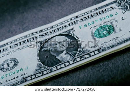 One dollar banknotes on a black table. Cash money american dollars. Vintage background. Lens flare. American currency.