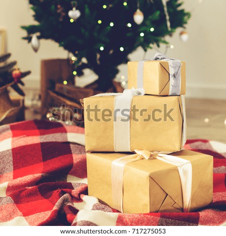 Beautiful Christmas interior design. Selective focus on gifts, on the background decorated room with Christmas tree, close-up, toned image. Concept of Christmas, winter and New Year