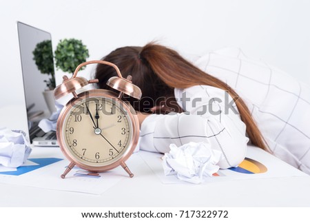 Overworked and tired businesswoman sleeping over a laptop in a desk at work in her office