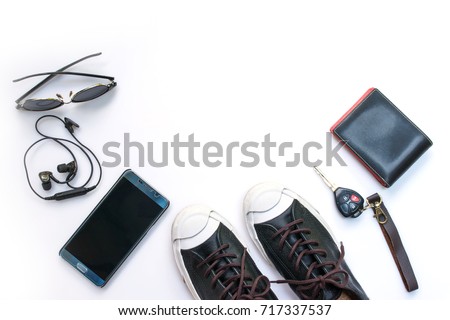 Sneaker shoes , mobile phone and other  accessories such as headphone , car key and eyeglass on white background , top view and copy space Royalty-Free Stock Photo #717337537