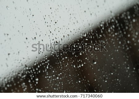 Raindrops on window with blurred background.