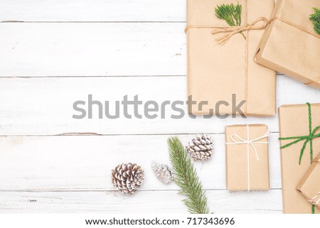 Christmas background with handmade present gift boxes and rustic decoration on white wooden board. Creative Flat layout and top view composition with border and copy space design.
