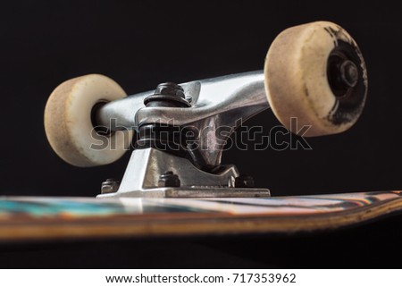 Close up of skateboard truck and wheels on black background. Advertizing safety construction of professional extreme sport devices and skateboarding elements. Axle, kingpin, bushing, hanger
