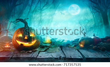 Halloween Pumpkins on wood. Halloween Background At Night Forest with Moon. Royalty-Free Stock Photo #717357535