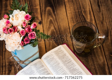 roses tea and bible on a wooden background